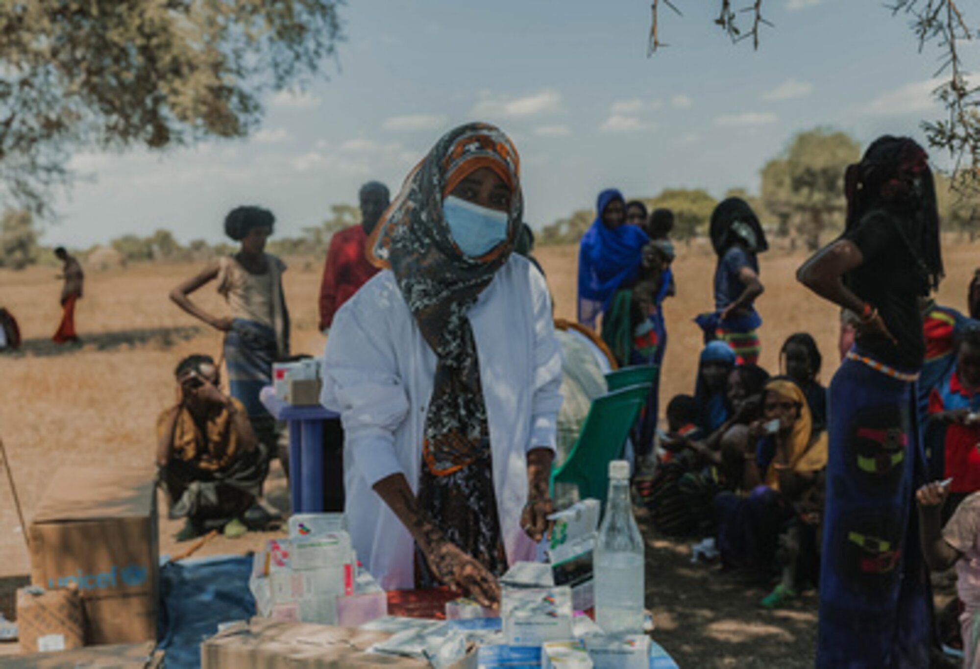 Photo of service provider in rural area, with mask and medical supplies