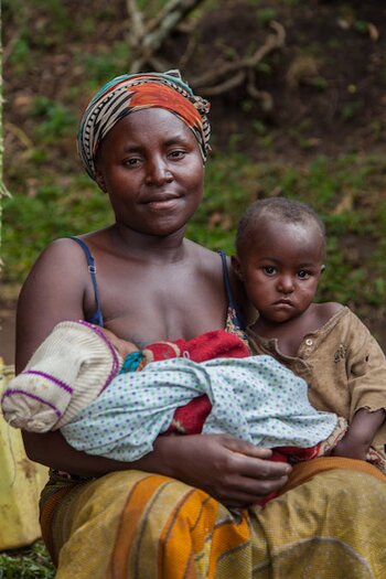Kabugho tient son enfant malade après avoir marché pendant des heures pour arriver au centre de santé.