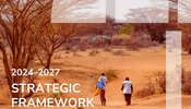 Couverture du cadre stratégique, avec le titre et une photo de deux prestataires de soins de santé marchant vers un village rural
