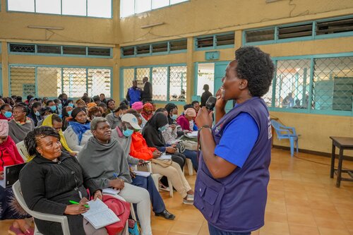 A woman speaks in front of a group of community mobilizers