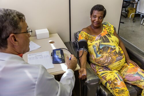 Doctor uses a sphygmomanometer to test the blood pressure of pregnant and diabetic patient.